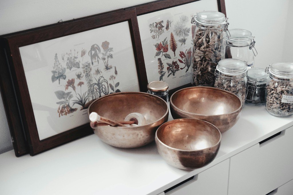 Wellness practice still life with singing bowls, botanicals, and dried herbs for health content