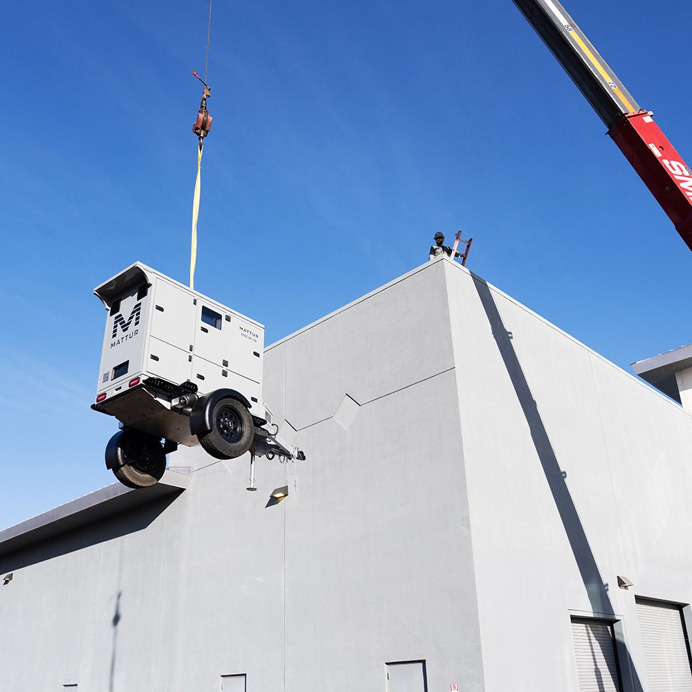 Mattur unit being lifted by crane onto a building