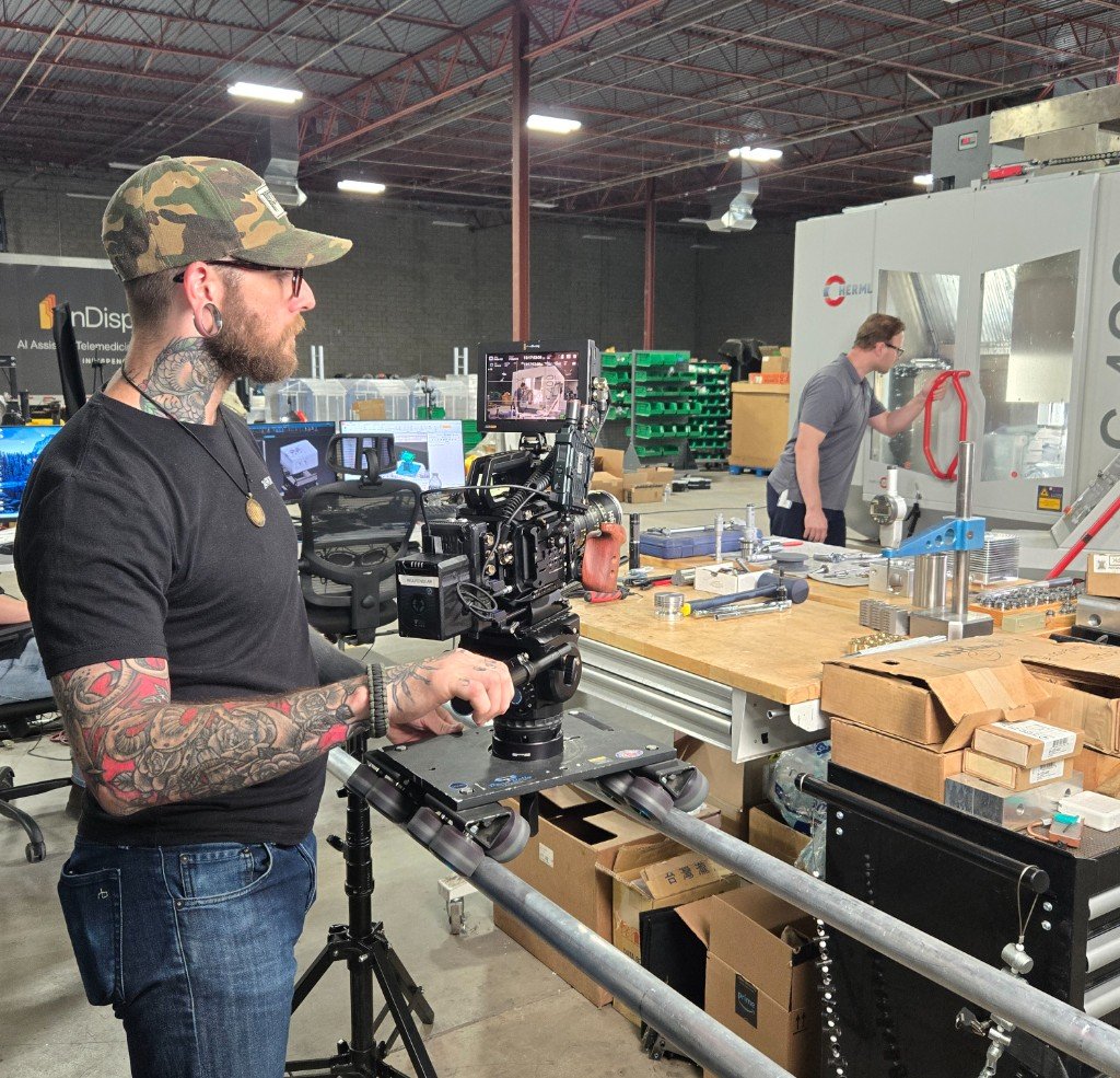 On-site videographer filming documentary content in a production workspace